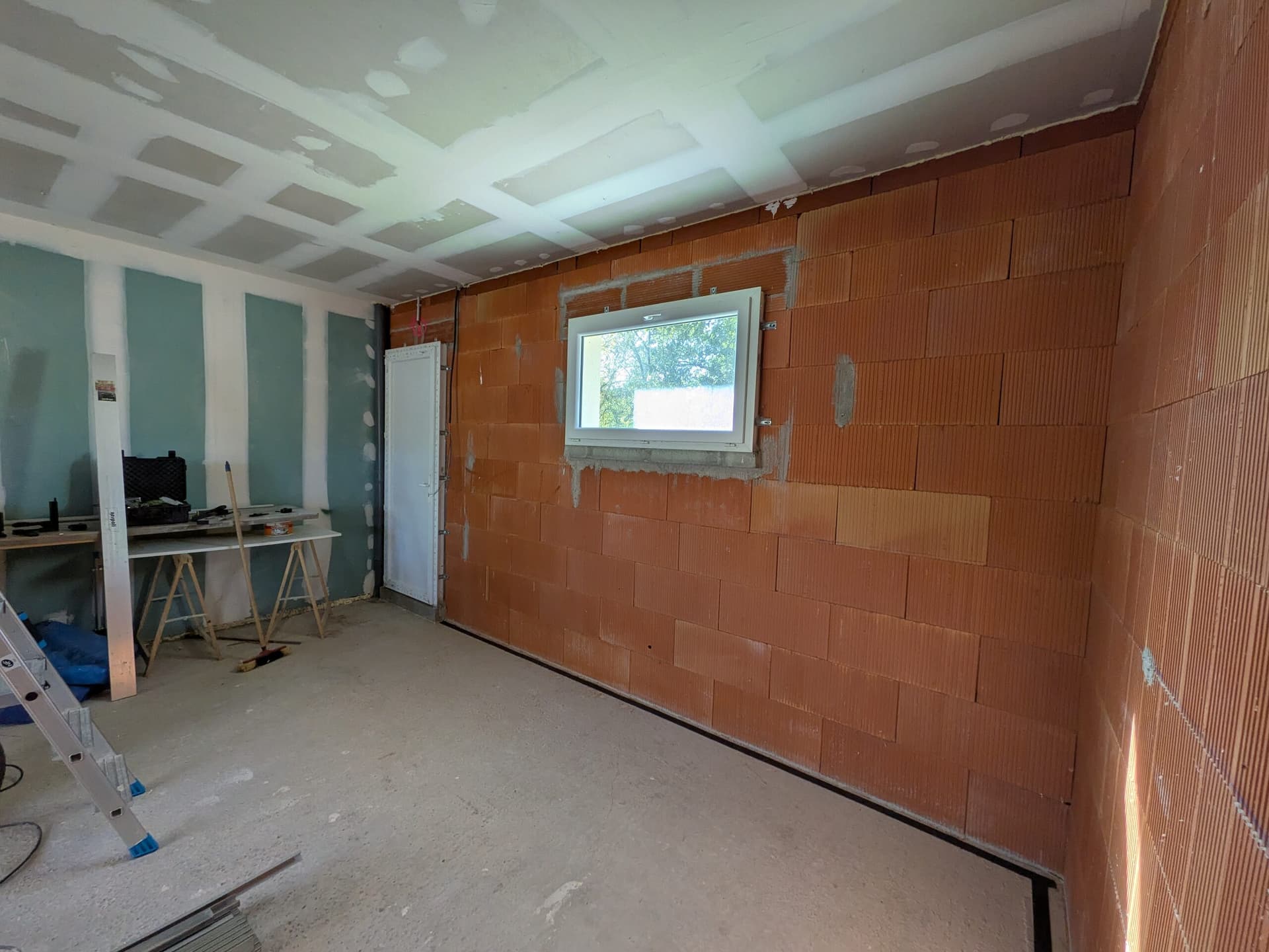 Mur de la porte de service et de la fenêtre avant travaux, mur mitoyen avec la maison déjà plaqué à gauche