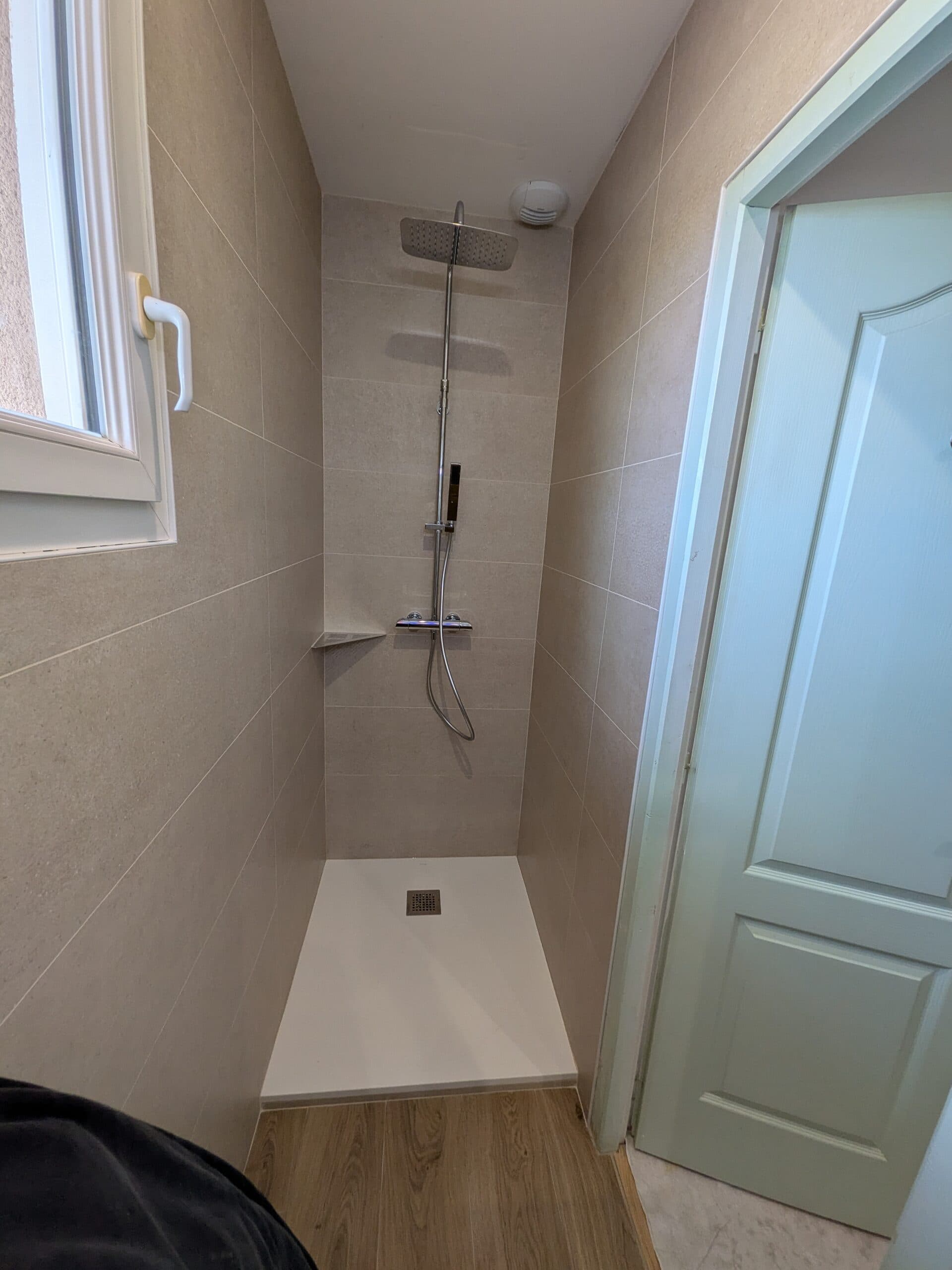 Receveur extra-plat blanc et colonne de douche thermostatique posés, faïence beige 30x90 en place avant la pose de la paroi