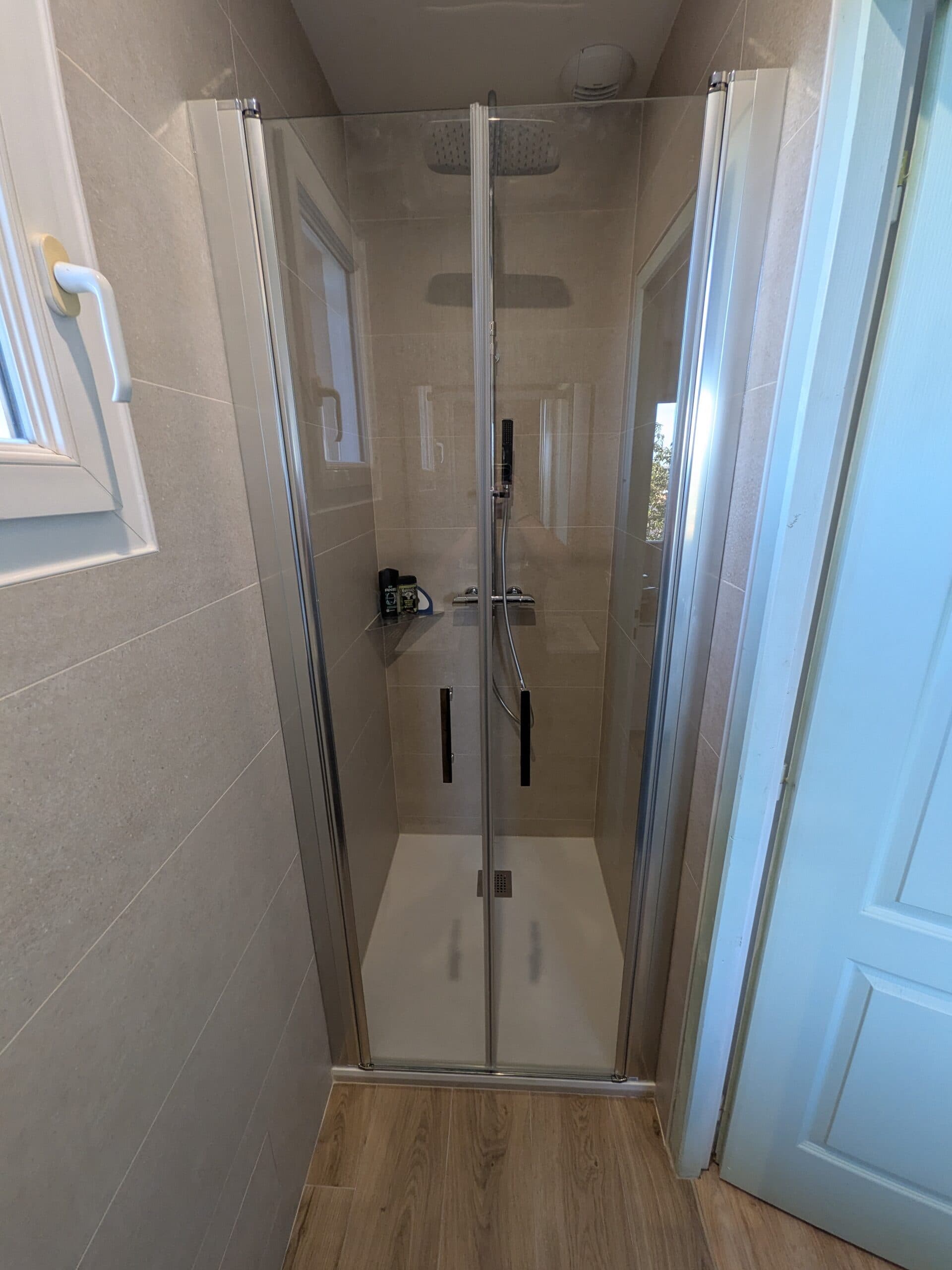 Douche terminée avec paroi à deux portes battantes type saloon et sol en carrelage imitation parquet 20x120