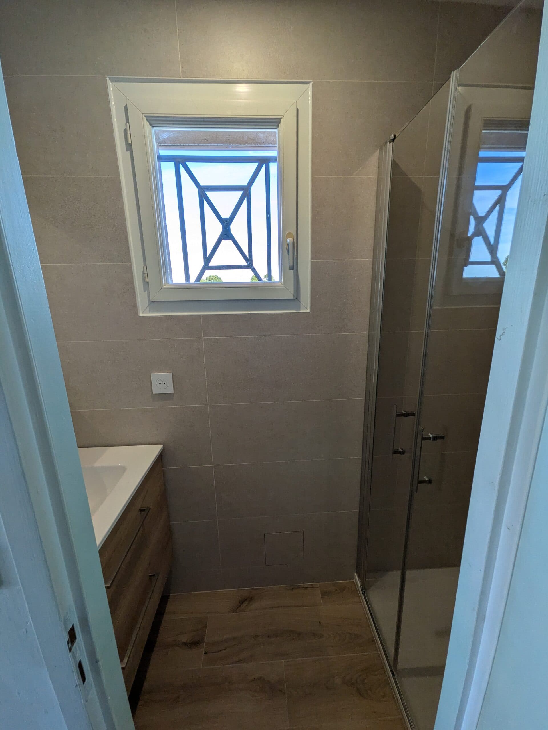 Vue d'ensemble de la première salle de bain terminée, trappe de visite de la nourrice encastrée sous la fenêtre