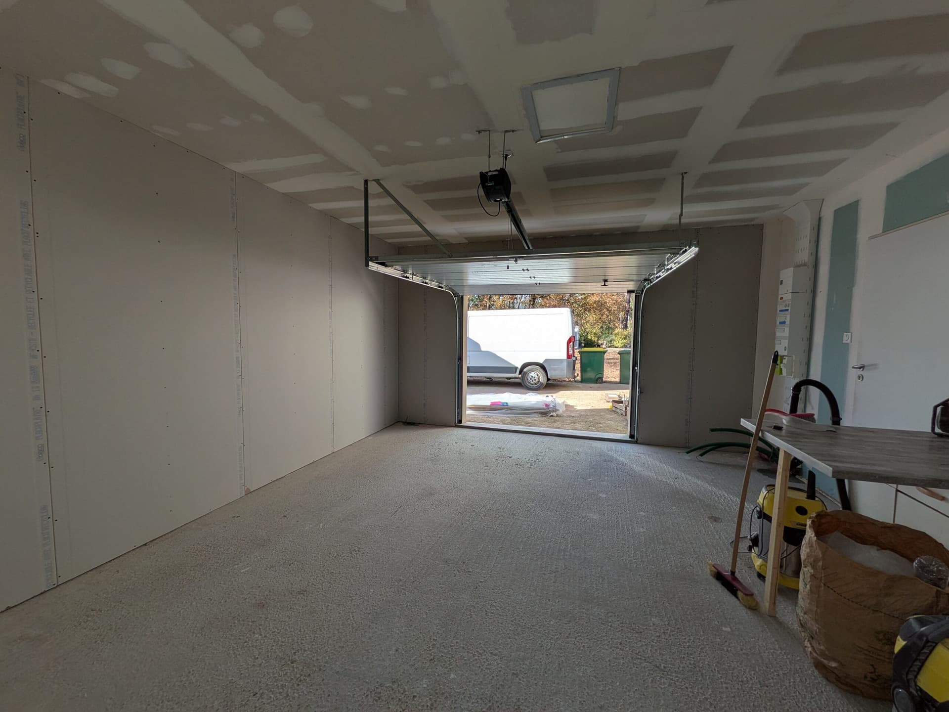 Grand mur plaqué vu vers la porte de garage ouverte