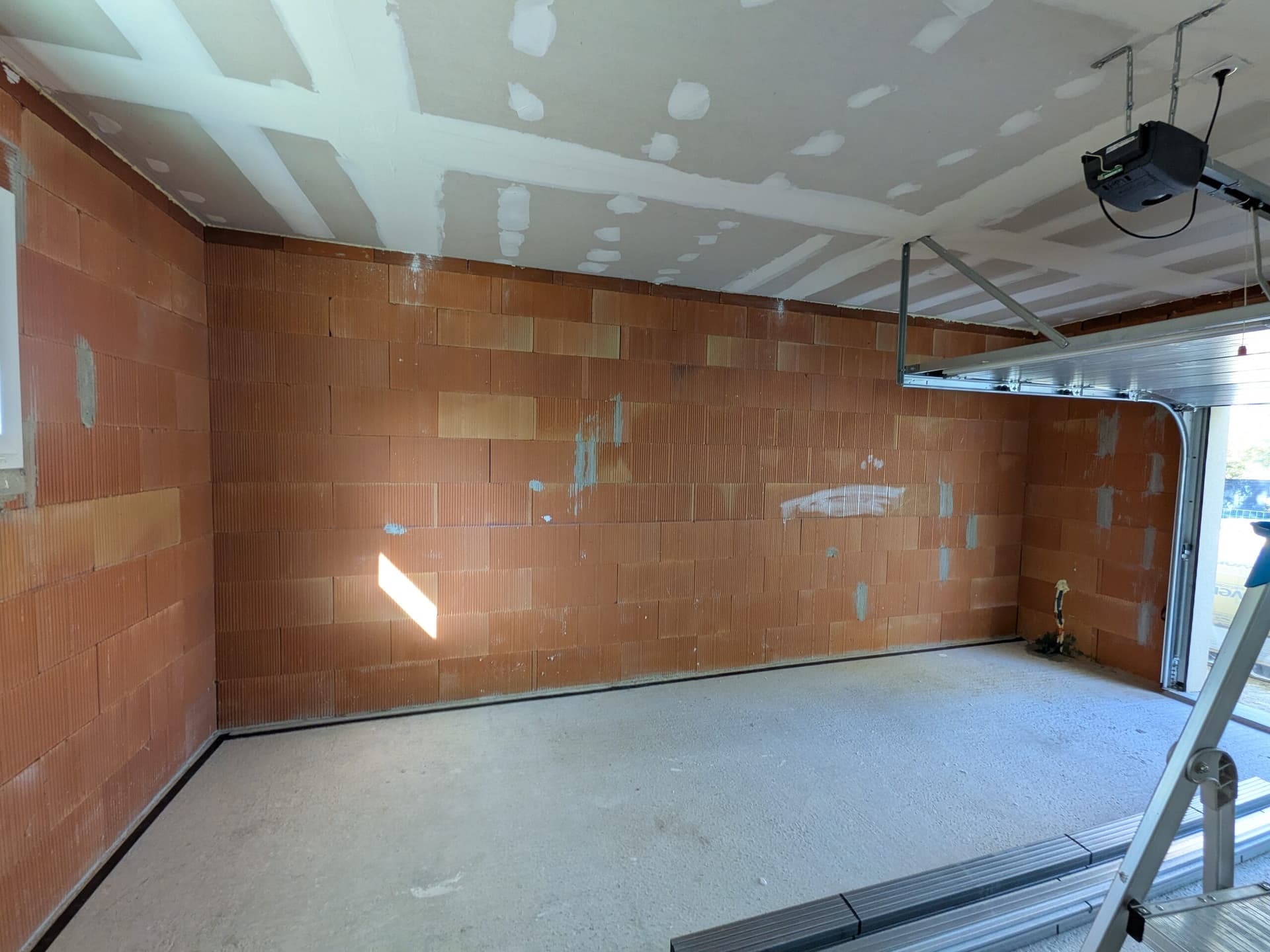 Grand mur en brique du garage avant isolation, plafond déjà plaqué