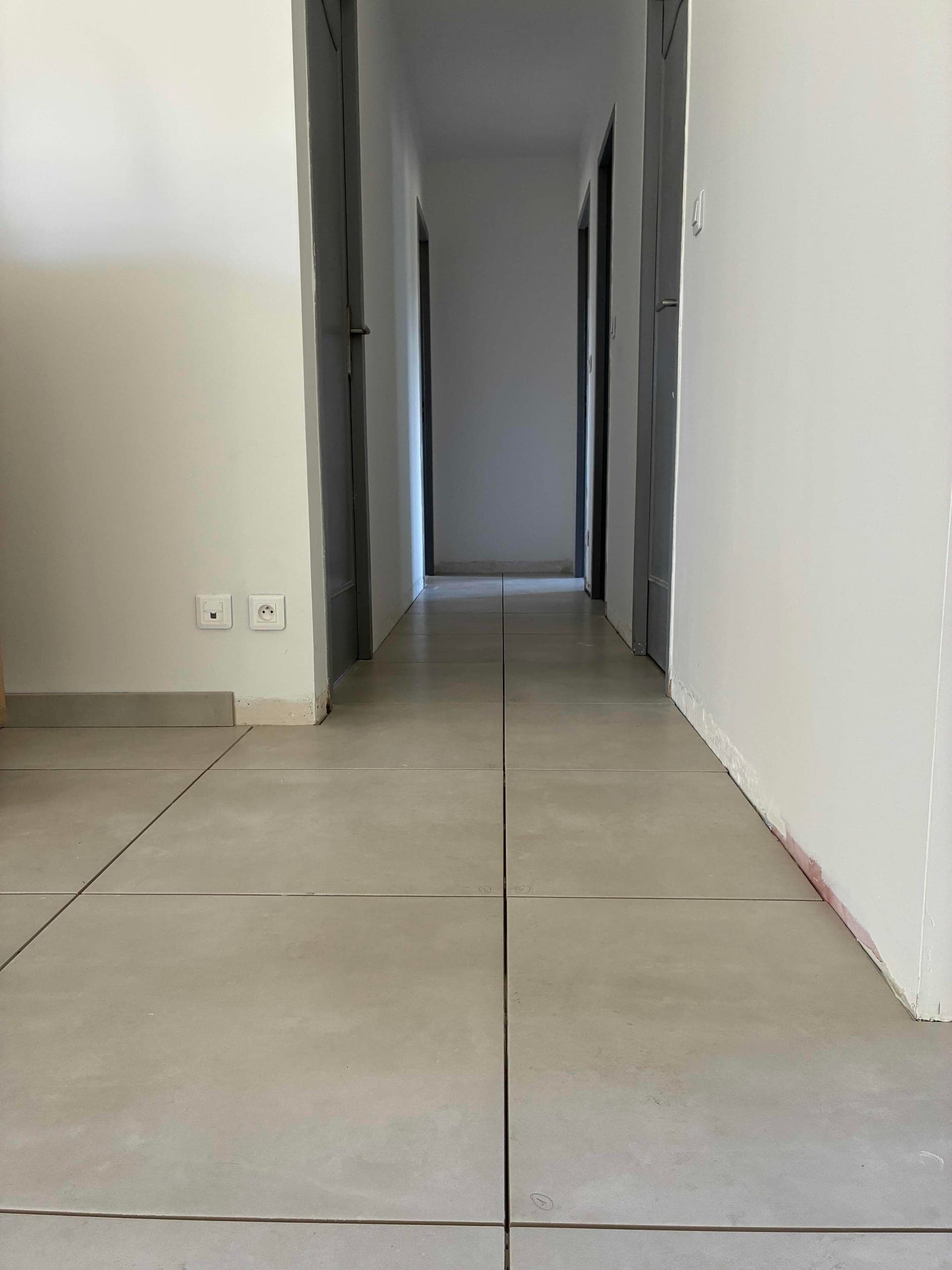 Carrelage 60x60 effet béton posé dans le couloir desservant les chambres