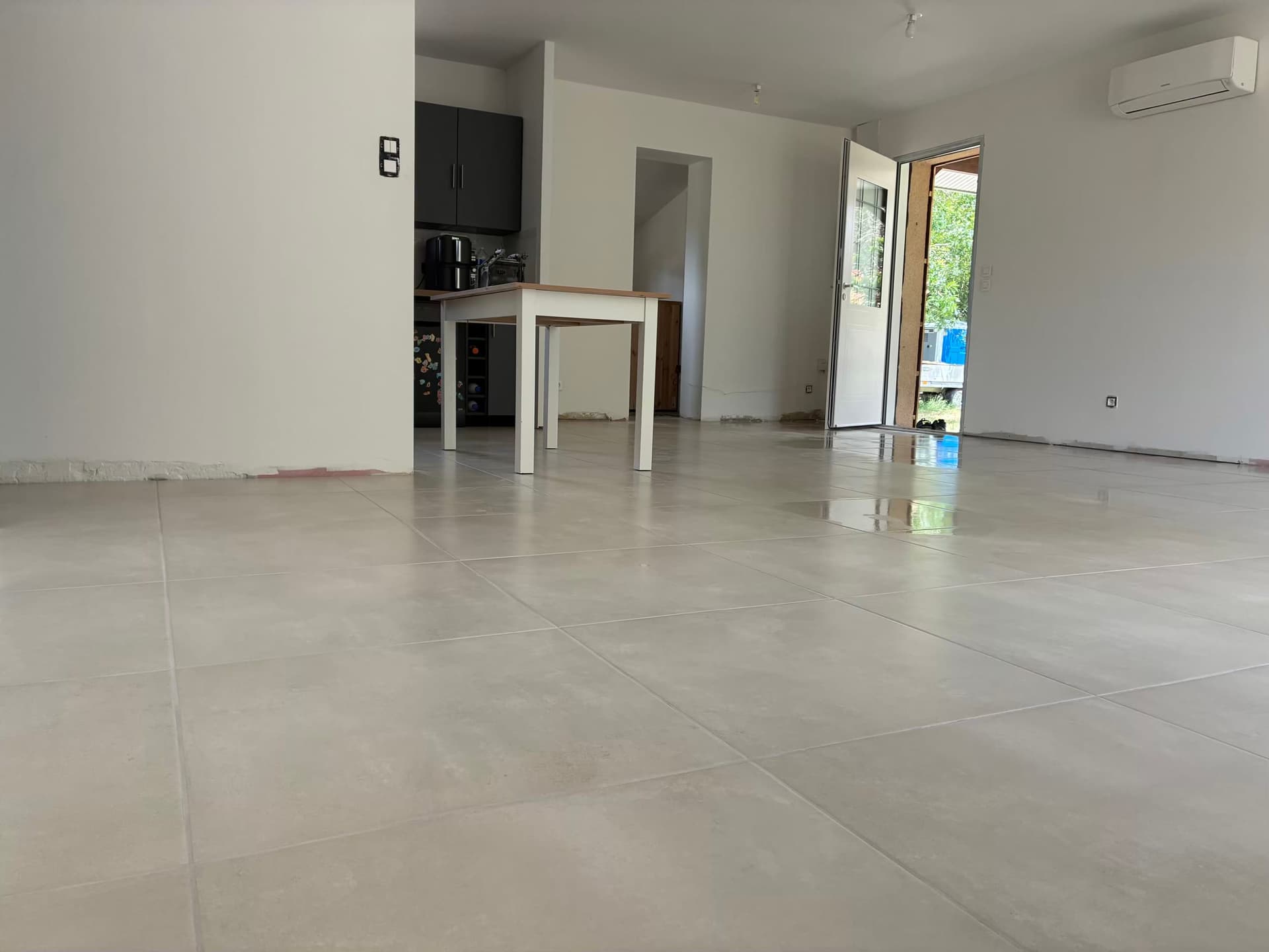 Séjour et cuisine ouverts avec le même carrelage 60x60 effet béton posé en continu